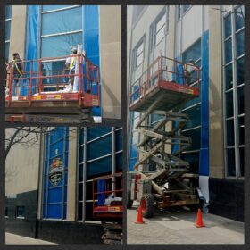 Technicians using scissor lift to install window graphics on Bank of Montreal