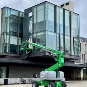Technicians using aerial lift to install window graphics at Ivey