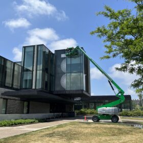 Technicians using aerial lift to install window graphics at Ivey