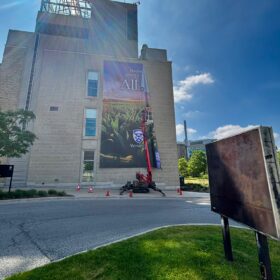 Large format vertical banners being installed by technicians for Western University